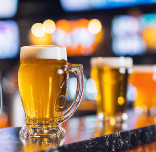 Image of mugs of beer sitting on a bar